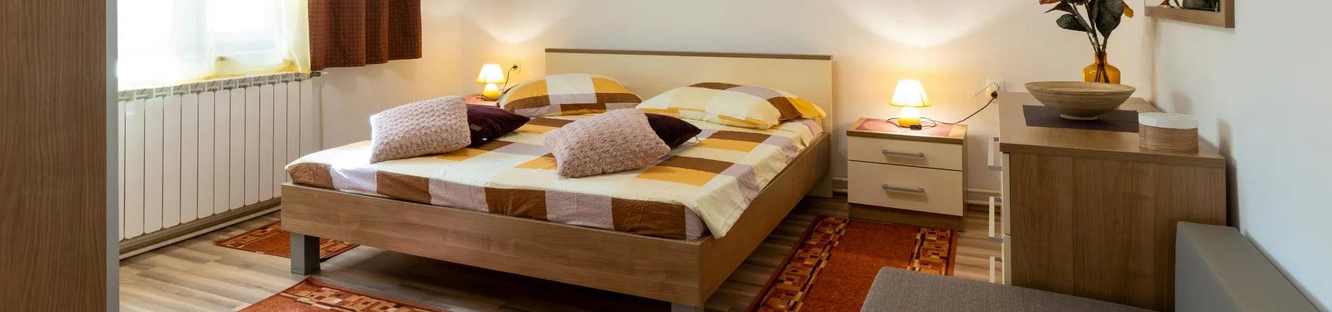 Handcrafted teak bedroom furniture featuring a bed, nightstands, and dresser in a cozy, stylish room