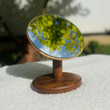 Wood Ceylon tabletop vanity mirror teak with round reflective surface and wooden base on white cloth