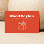 Wood Ceylon gift card in burnt orange with white text and gift box illustration on natural stone background