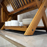 Wood Ceylon wooden dish drying rack holding white plates and cups on kitchen countertop