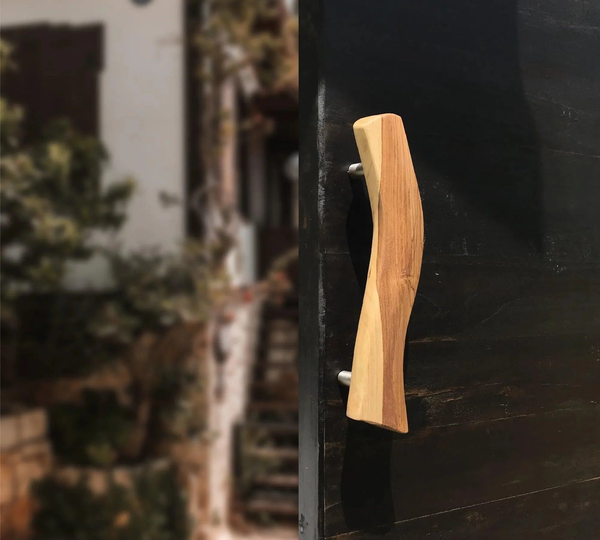 Wood Ceylon wooden Screen Door Handle with natural finish mounted on a black door