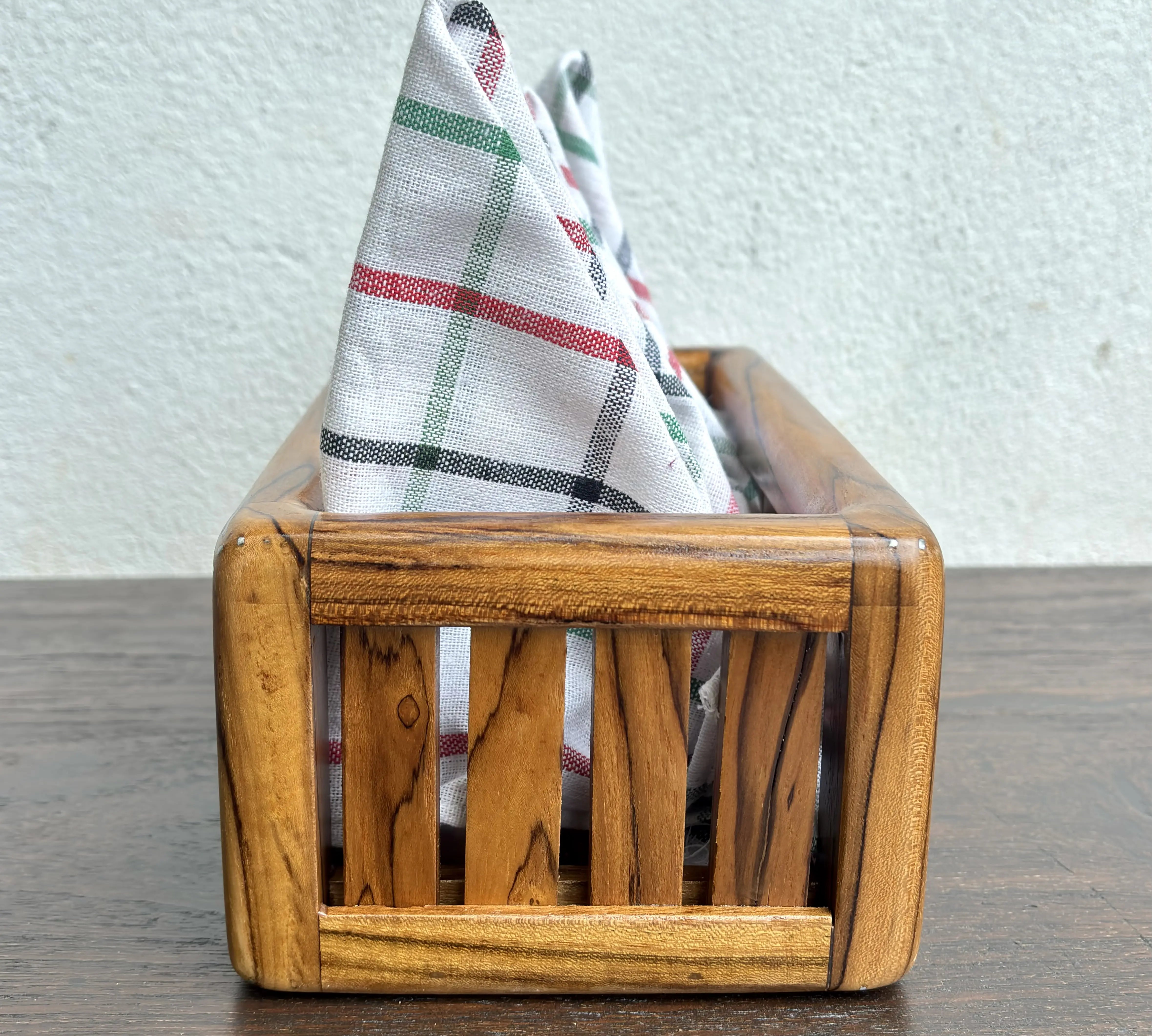 Wood Ceylon wooden towel box storage with slatted sides holding folded checkered towels